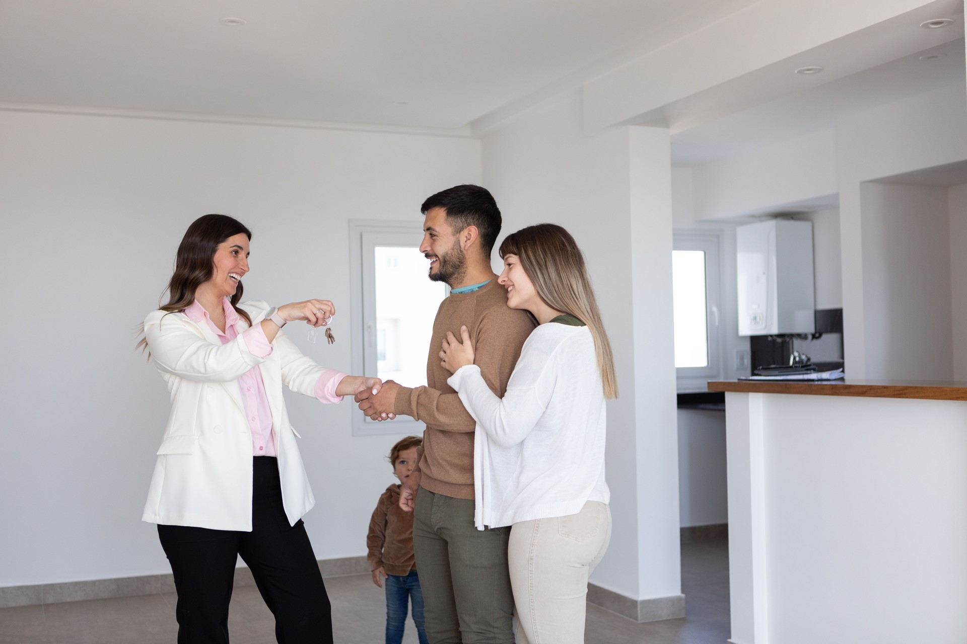 Real estate agent and young family receiving key of new home